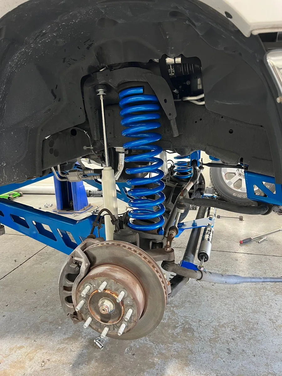Truck suspension with blue coil springs and brackets
