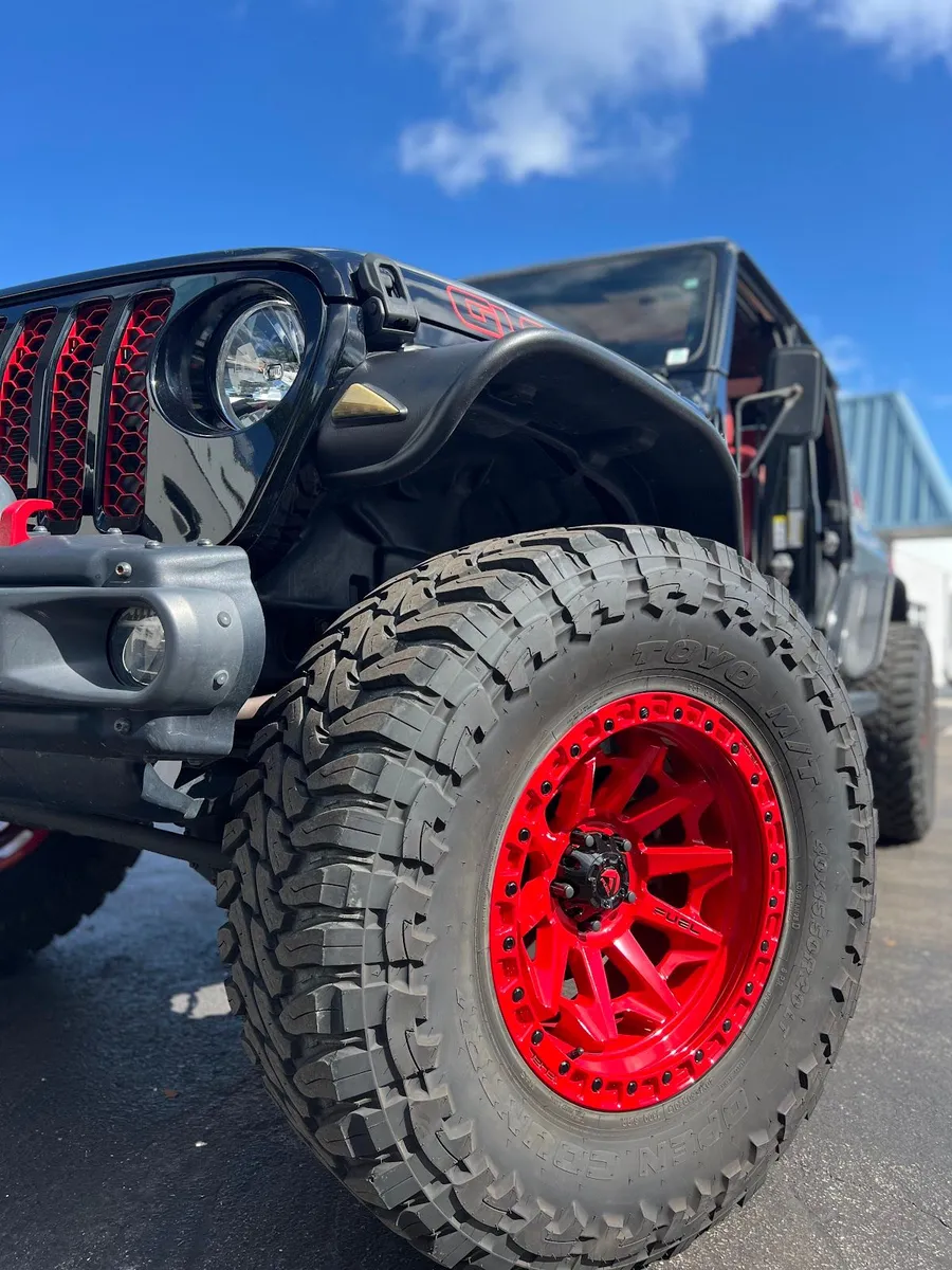 Lifted Jeep with gloss red wheels